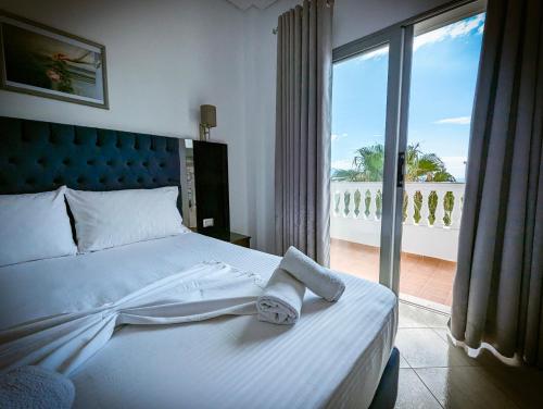 a bedroom with a bed with a view of a balcony at Hotel Fron in Sarandë