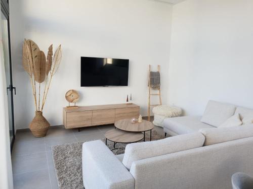un soggiorno con un divano e una TV a parete di Casamarcati a Calasparra