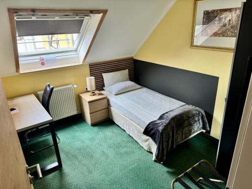a small bedroom with a bed and a window at Hotel Residenz Stockstadt in Stockstadt am Main