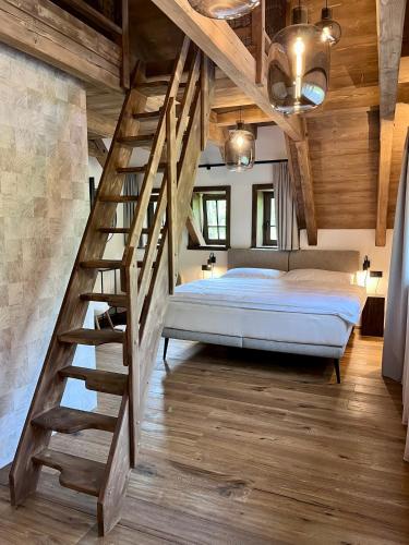 a bedroom with a large bed and a staircase at Roubenka Pod hvězdami in Strážné