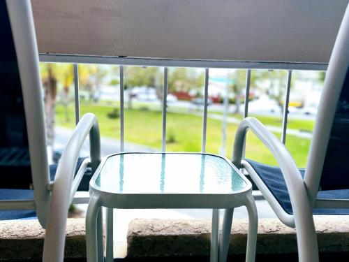 a glass table and chairs sitting on a window sill at The Pacific Inn in Seal Beach
