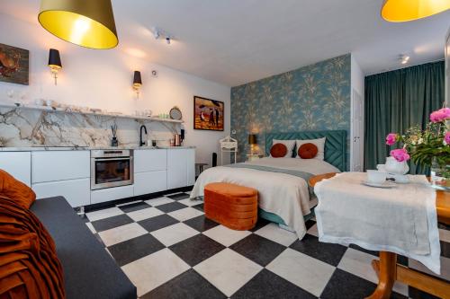 a bedroom with a bed and a checkered floor at Kolkside Studio in Delft