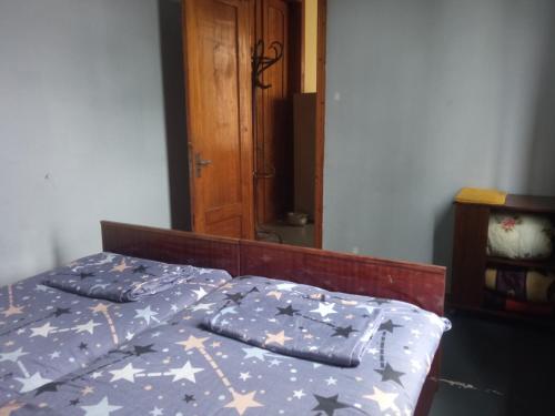a bed with a blue comforter with stars on it at One bedroom room in Zugdidi