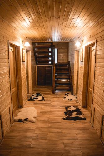 a hallway of a cabin with a wooden ceiling and stairs at Cabana Iulian in Petrila