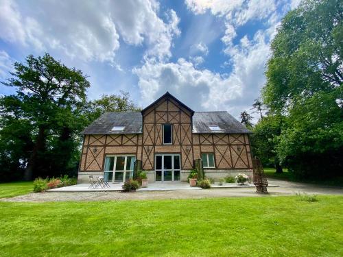 uma casa estilo celeiro com um relvado verde em Château D'Apigné Rennes em Le Rheu