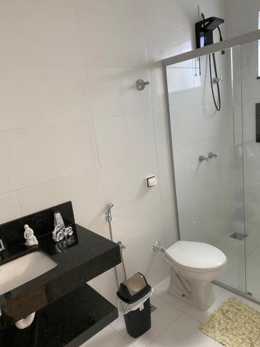 a bathroom with a toilet and a sink and a shower at Casa Capitólio com Vista para Escarpas do Lago in Capitólio