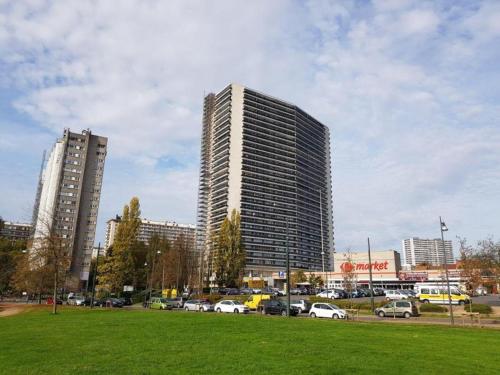 un edificio alto con coches estacionados en un estacionamiento en Appart meublé 92m2 + 2 terrasses en Bruselas