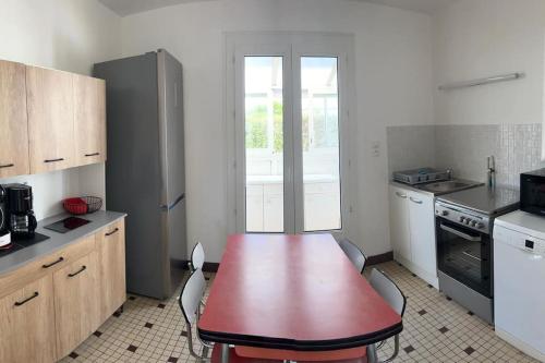 - une cuisine avec une table rouge et des chaises dans l'établissement Maison historique familiale 300m de la mer Sword Beach, à Ouistreham