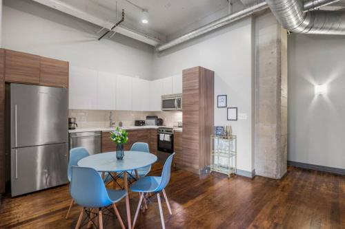 a kitchen with a table and chairs and a refrigerator at Stunning Downtown Apartment with Pool, Laundry, Parking in Dallas
