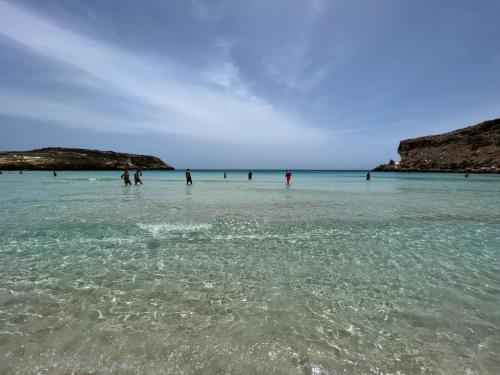 a group of people in the water at the beach at Mimma house in Lampedusa