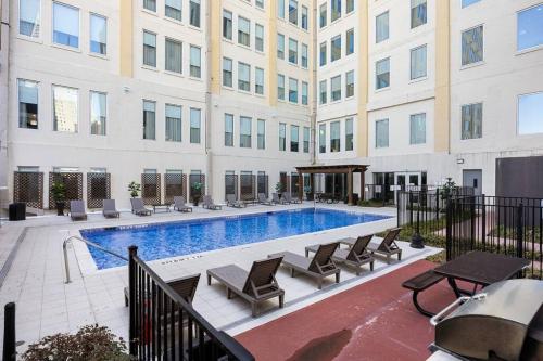 a swimming pool in front of a building at Stunning Downtown Apartment with Pool, Laundry, Parking in Dallas