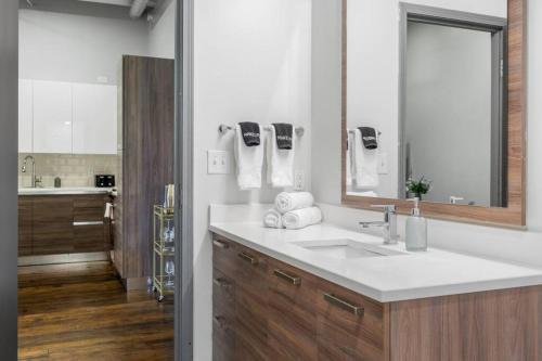 a bathroom with a sink and a mirror at Stunning Downtown Apartment with Pool, Laundry, Parking in Dallas
