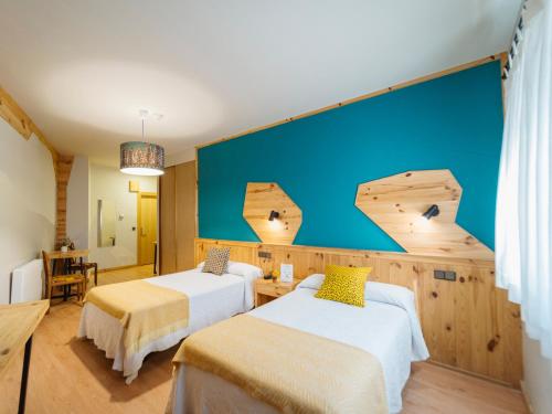 Habitación con 2 camas y pared azul en Hotel San Miguel, en Gijón