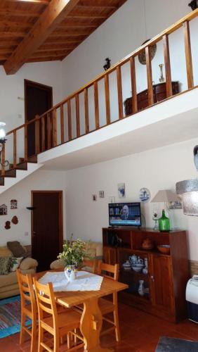 a living room with a table and a staircase at Casa do Granel in Sete Cidades