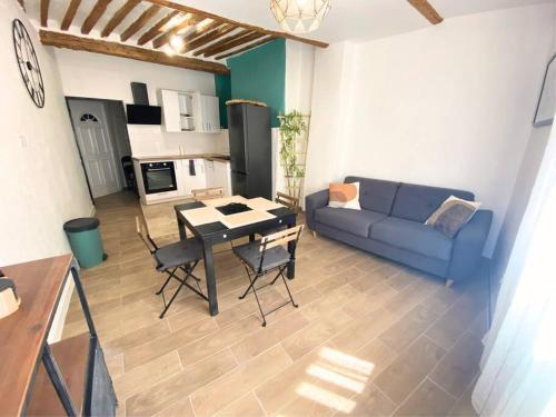 un salon avec un canapé bleu et une table dans l'établissement Duplex T2 Carpentras centre-ville, à Carpentras