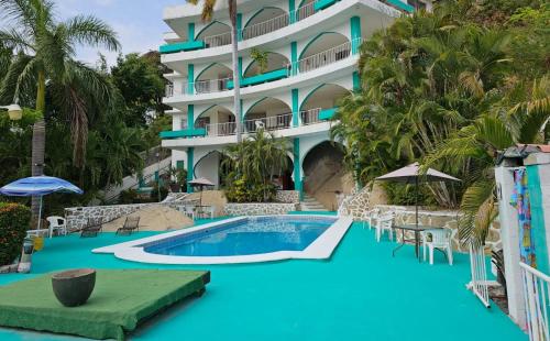 a resort with a swimming pool and a building at Casa Costa Brava in Acapulco