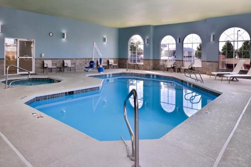 een groot zwembad met blauw water in een gebouw bij Holiday Inn Express Hotel & Suites Farmington, an IHG Hotel in Farmington