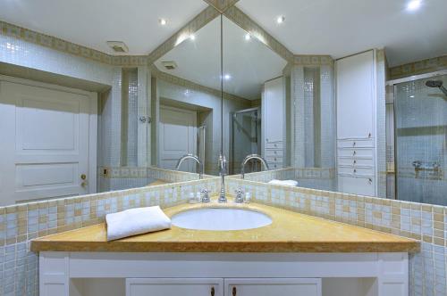 a bathroom with a sink and a large mirror at IREX Colosseo & Fori, Elegant 3 rooms apartment in Rome