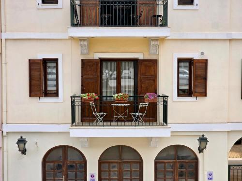 a building with a balcony with chairs and flowers on it at Master Residence Lavrion in Lávrion