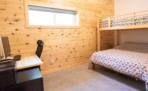 Schlafzimmer mit einem Bett, einem Schreibtisch und einem Etagenbett in der Unterkunft Elk in Audet