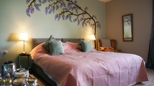 a bedroom with a pink bed with purple flowers on it at The Star in Narberth in Narberth