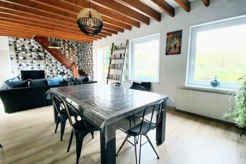 d'une salle à manger avec une table et des chaises dans le salon. dans l'établissement Charmante maison de campagne avec jardin, à Annezin