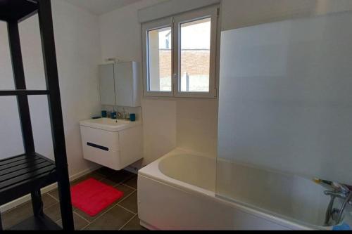 une salle de bain avec baignoire et toilettes et une fenêtre dans l'établissement Charmante maison de campagne avec jardin, à Annezin