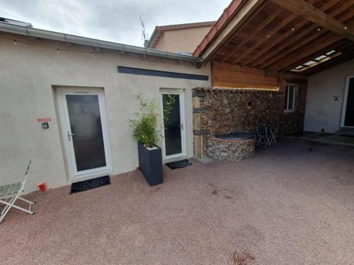 a house with a patio with a plant in it at Le Riad, sauna & jacuzzi in Riorges