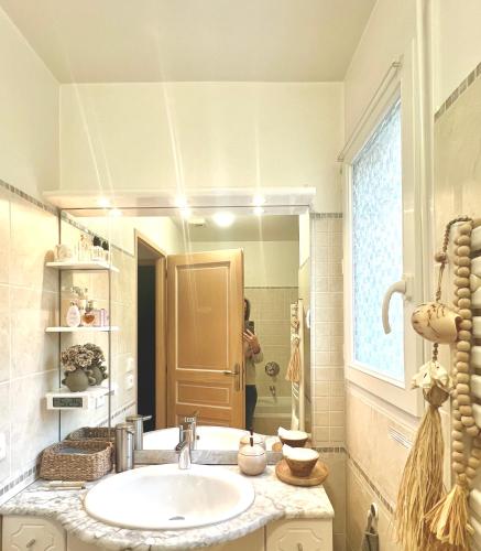 une salle de bain avec un lavabo et un grand miroir dans l'établissement Chambre au calme l jardin I tram l Grenoble Nord St Egreve, à Saint-Égrève