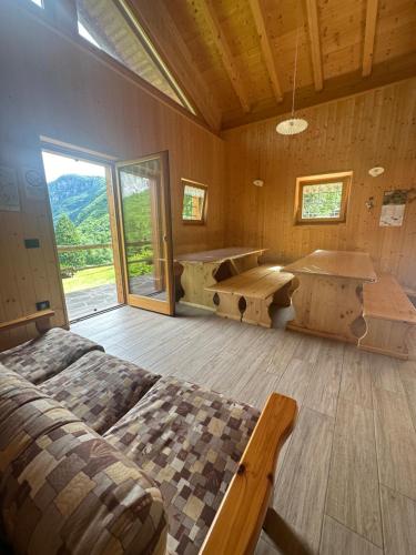 a room with two beds and a tub in it at Baita Lomasona in Comano Terme