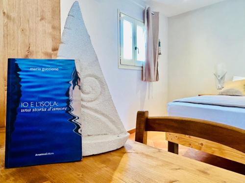 a book sitting on a table next to a bed at Alencio Comfort Urbano in Favignana