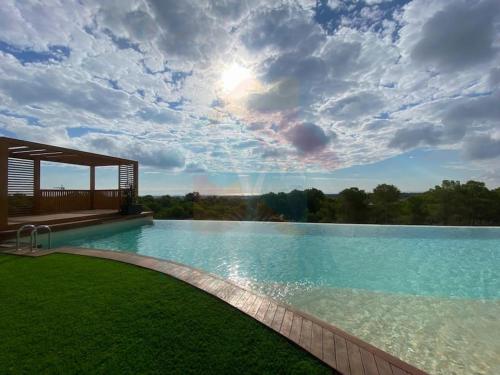 a large swimming pool with a cloudy sky above it at Limonero16 in Orihuela Costa