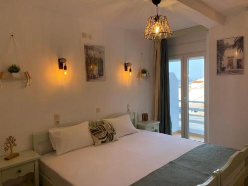 ein Schlafzimmer mit einem Bett und einem großen Fenster in der Unterkunft Ξενοδοχειο Julietta in Patitiri