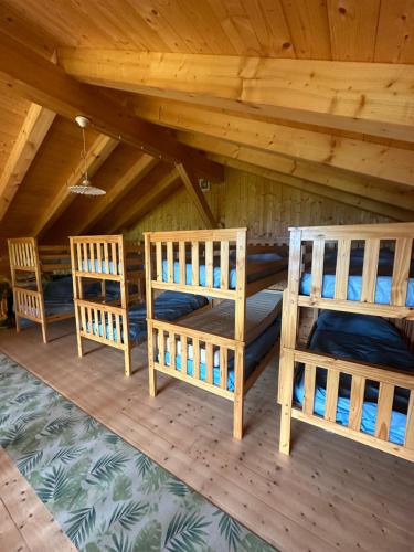 a room with three bunk beds in a cabin at Baita Lomasona in Comano Terme