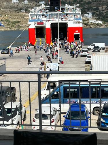 un groupe de personnes dans un parking à côté d'un ferry dans l'établissement Captain's Port Studio, à Gavrio