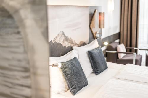 a bedroom with a bed with pillows and a mountain mural at zum Senner Suites Zillertal in Schlitters