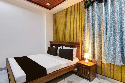 a bedroom with a bed and a window with a curtain at Collection O SV Delight Inn in Hyderabad