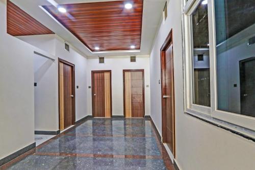 a hallway with wooden doors and a ceiling at Collection O SV Delight Inn in Hyderabad