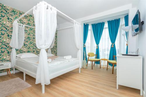 - une chambre avec un lit blanc et des rideaux bleus dans l'établissement SPOT Vama Veche, à Vama Veche