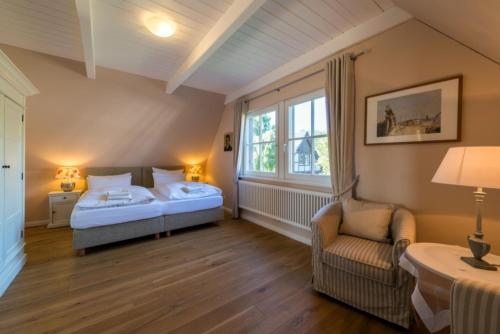 ein Schlafzimmer mit einem Bett, einem Stuhl und einem Fenster in der Unterkunft Fischerhaus in Quilitz in Quilitz