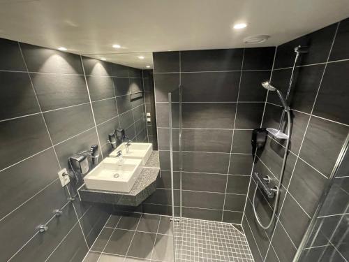 La salle de bains est pourvue d'un lavabo et d'une douche. dans l'établissement Gausta View Lodge, à Gaustablikk
