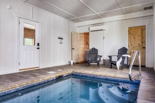 a swimming pool in a house with two chairs at Private Indoor Pool Cabin w/ Game Room & Hot Tub! in Pigeon Forge