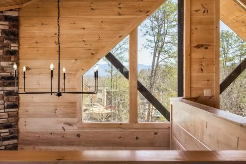 a room with a large window and a chandelier at Private Indoor Pool Cabin w/ Game Room & Hot Tub! in Pigeon Forge