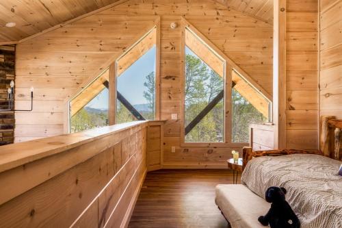 a bedroom in a log cabin with large windows at Private Indoor Pool Cabin w/ Game Room & Hot Tub! in Pigeon Forge