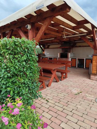 a group of wooden benches sitting under a pavilion at Aranymandula apartmanok in Balatonakali