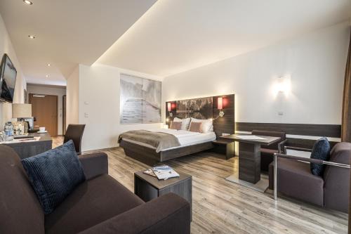 Habitación de hotel con cama y sofá en zum Senner Suites Zillertal, en Schlitters