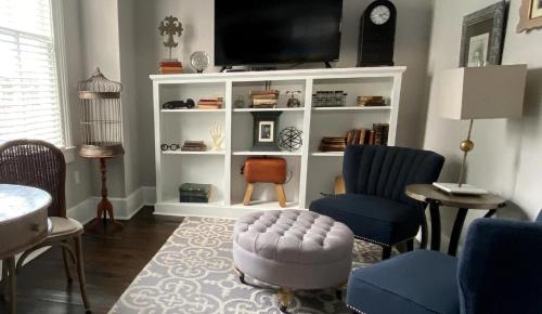 a living room with a tv on a white book shelf at Hotel Laurance in Luray