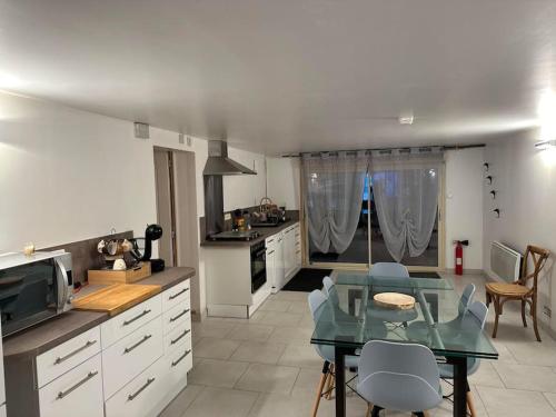une cuisine avec une table en verre dans l'établissement Le Petit Bonheur, à Escamps