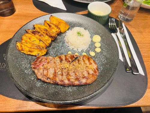 a plate of food with meat and rice on a table at Transamerica Executive Sorocaba in Sorocaba
