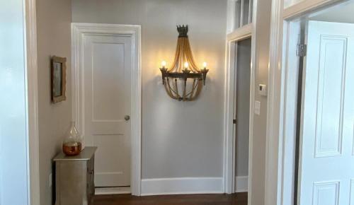 a hallway with a chandelier next to a door at Hotel Laurance in Luray